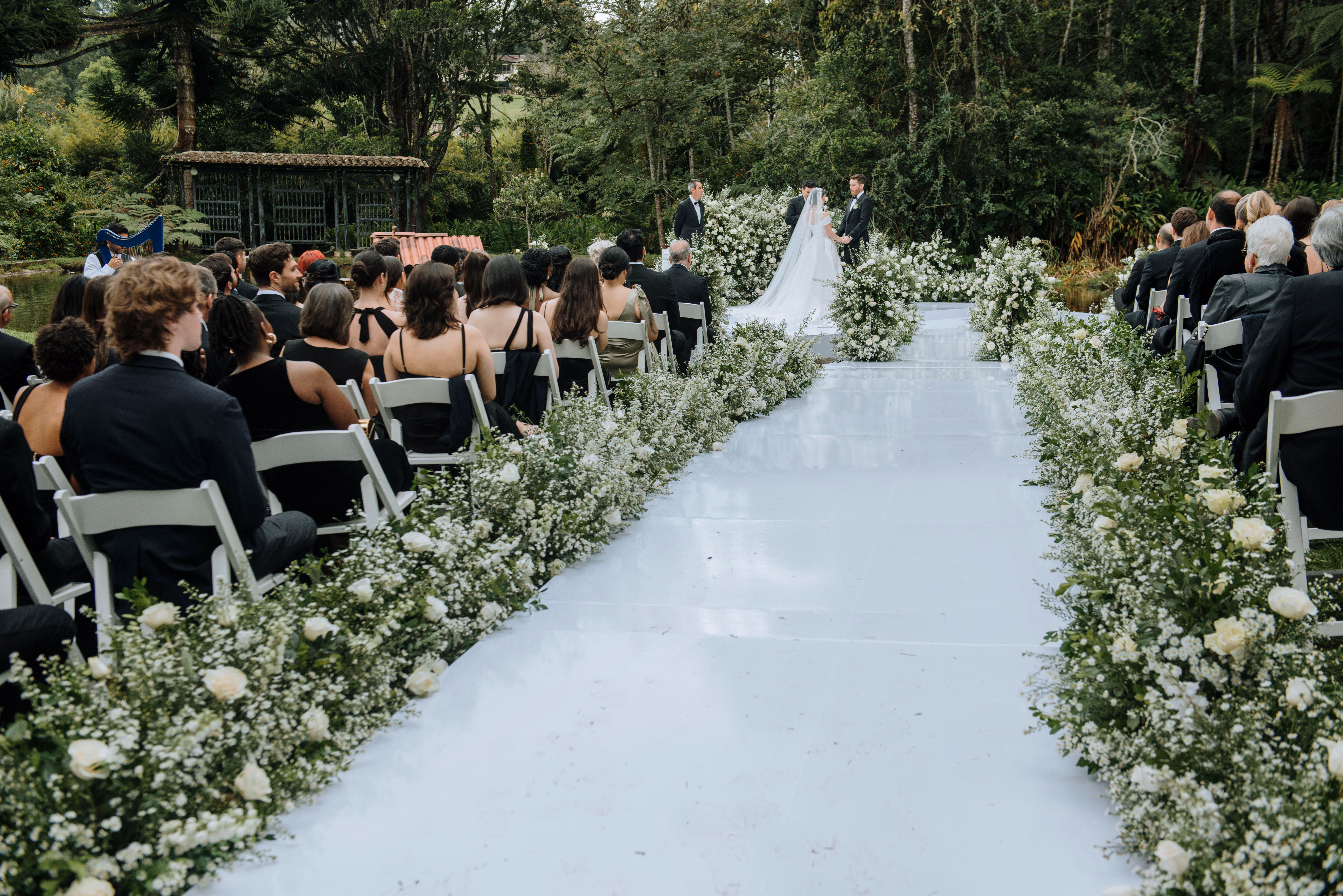 Ceremonia de boda al aire libre rodeada de flores blancas