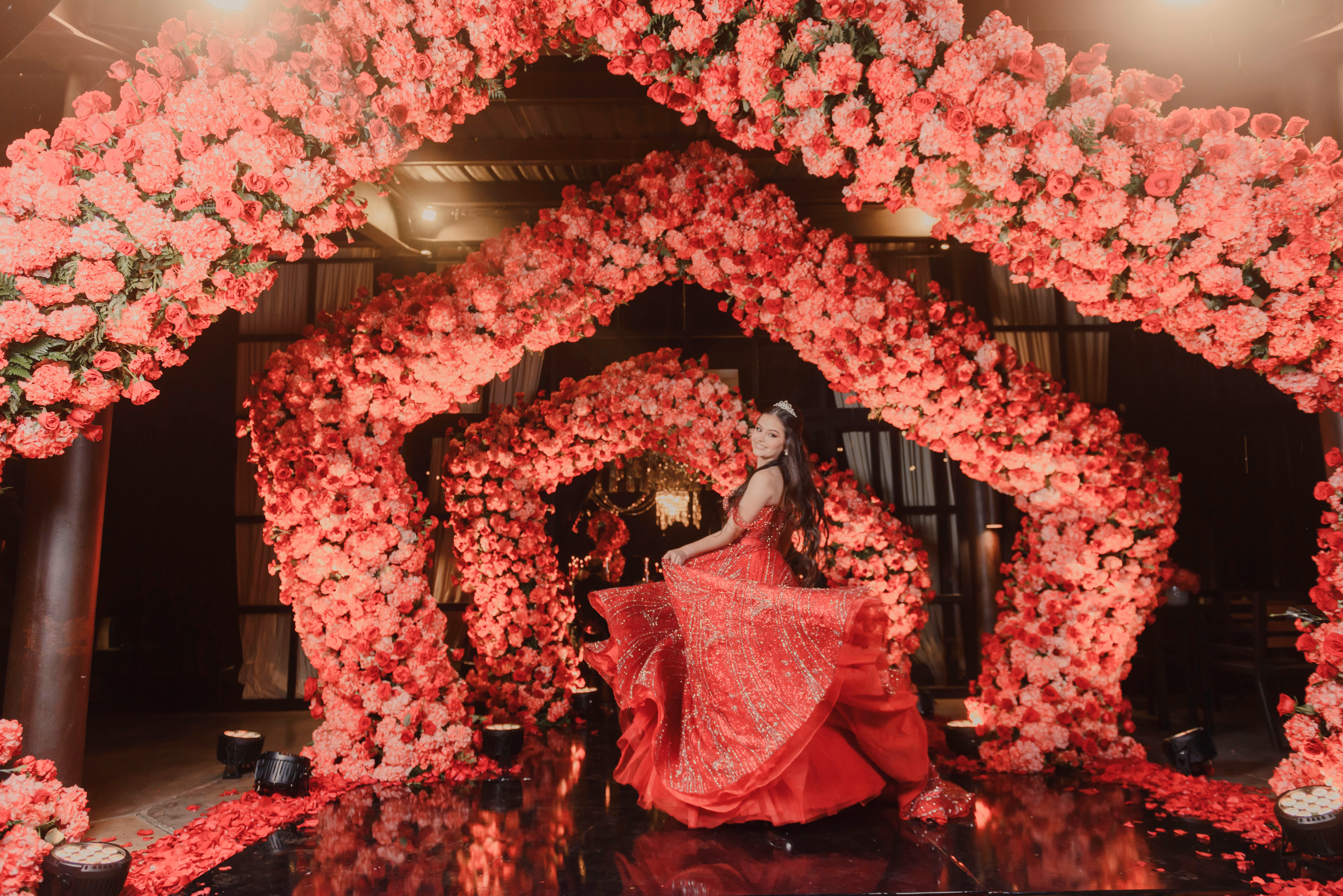 Quinceañera con vestido rojo en una celebración de gran formato
