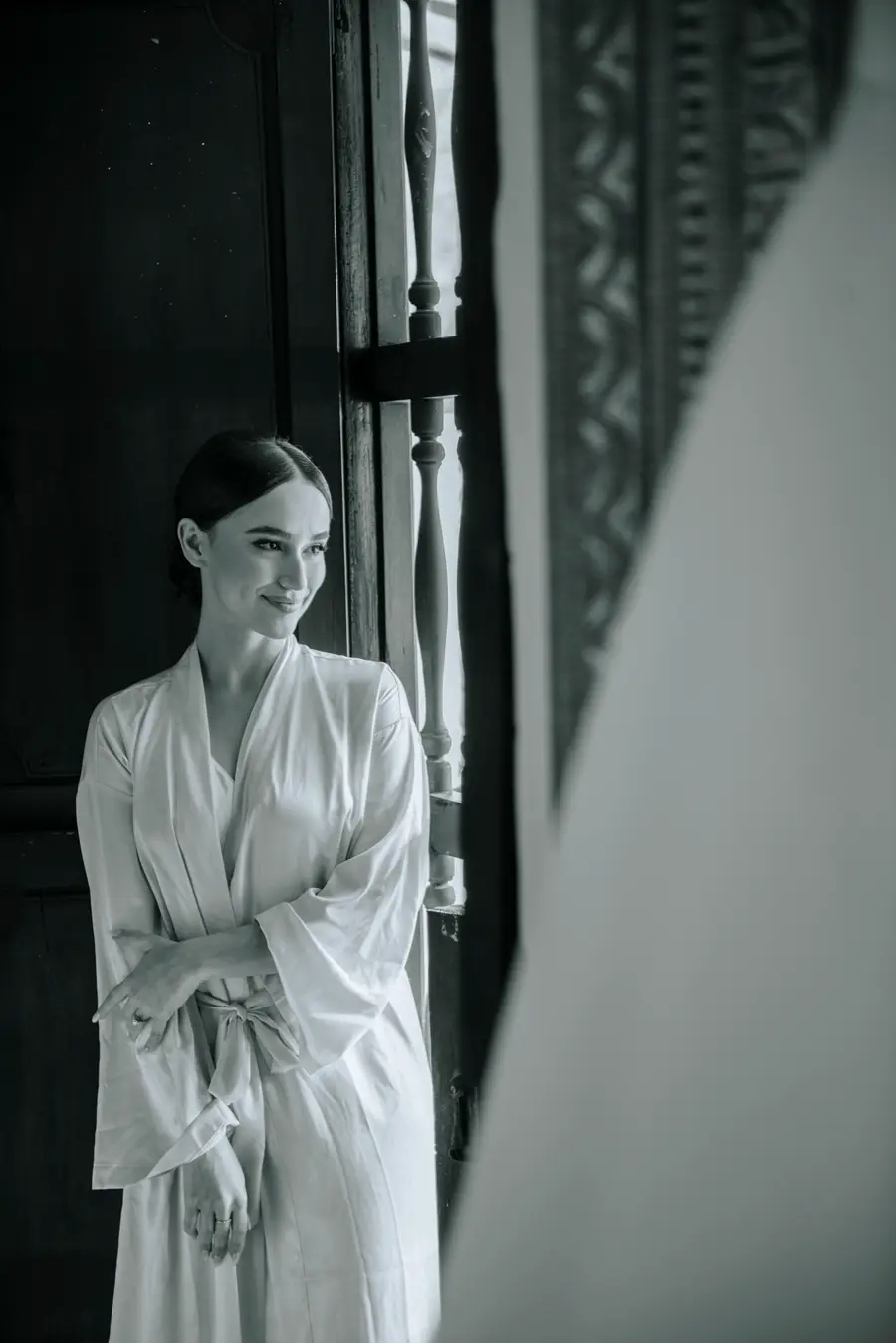 Retrato en blanco y negro de una novia junto a una ventana